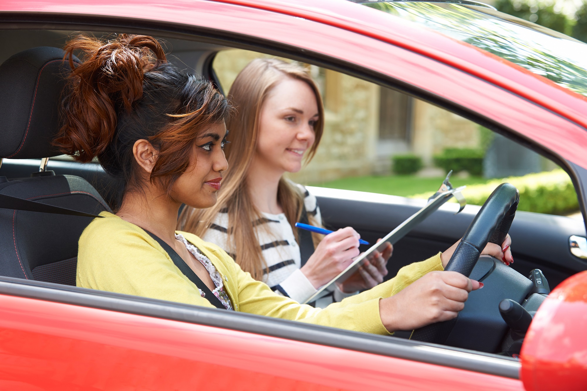 Young woman having a driving lesson with her instructor