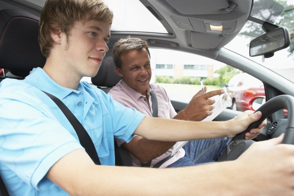 Learner driver and driving instructor talking while the pupil drives