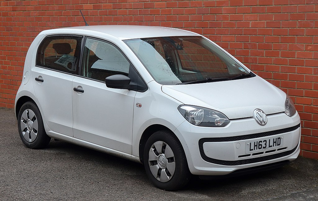 White VW Up! pictured in front of orange brick wall