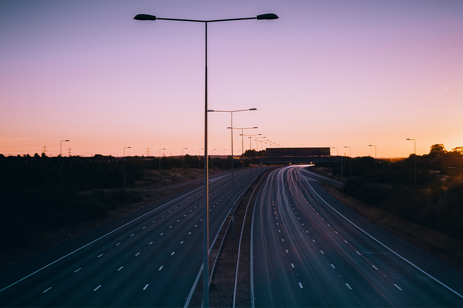 Empty motorway with sun setting in background