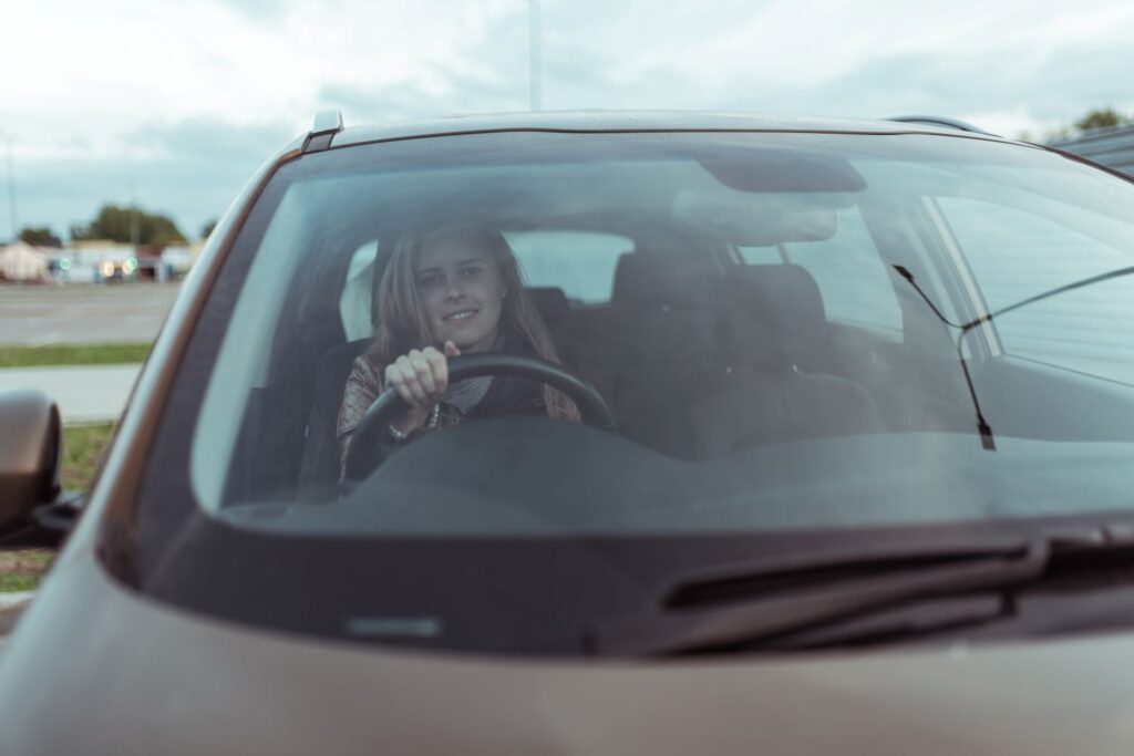 Young woman smiling at the camera from the driving seat