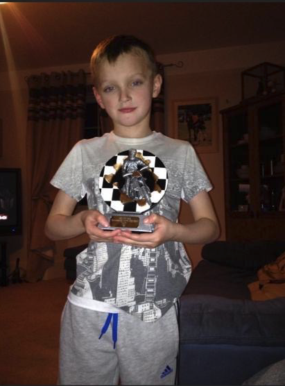 Ollie with the first motocross trophy he won, aged six.